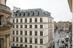 a large white building with a gray roof on a city street at Hotel de Seze in Paris