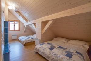 a bedroom with two beds in a room with wooden walls at Orlí Hnízdo in Štramberk