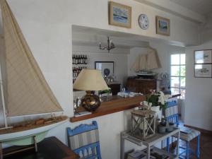 a living room with blue chairs and a table with a lamp at Le Buzet Bleu Bed & Breakfast in Noirmoutier-en-l'lle