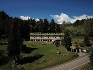 duży biały budynek na zielonym polu obok drogi w obiekcie Gran Hotel Panamericano w mieście Bariloche