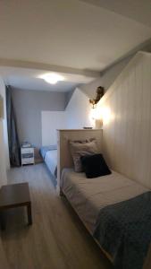 1 dormitorio con 1 cama grande y 1 mesa en La Charretterie, en Martragny