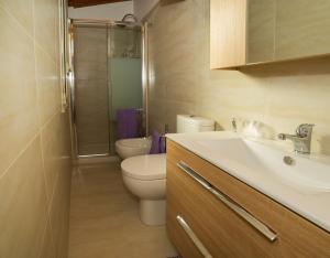 a bathroom with a toilet and a sink and a shower at Casa del Melograno 42 in Roccalumera