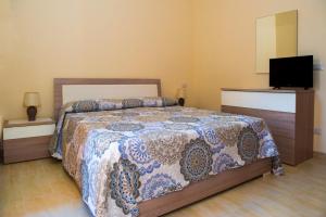 a bedroom with a bed and a flat screen tv at Casa del Melograno 42 in Roccalumera