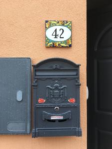 un buzón negro al lado de un edificio en Casa del Melograno 42, en Roccalumera