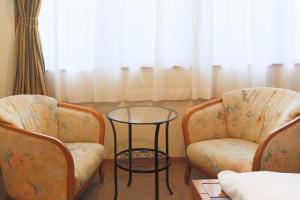 two chairs and a glass table in a room at HAKONE GORA ONSEN Hotel Kasansui in Hakone