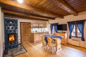 una cucina con tavolo, sedie e camino di ANTIK a Štramberk