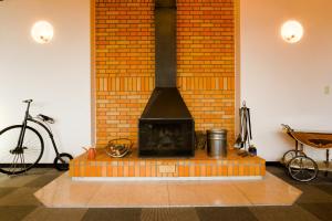 a brick fireplace in a room with a bike at HAKONE GORA ONSEN Hotel Kasansui in Hakone