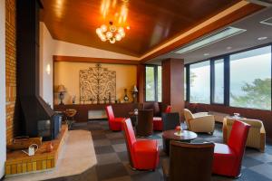 a restaurant with red chairs and tables and a fireplace at HAKONE GORA ONSEN Hotel Kasansui in Hakone