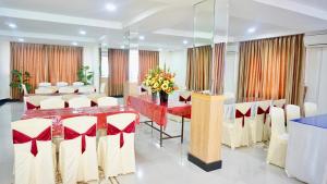 una sala de conferencias con una mesa larga y sillas blancas en Bintan Lumba Lumba Inn Hotel, en Tanjung Pinang