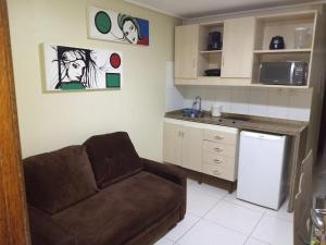 a living room with a couch and a kitchen at Manaíra Palace Residence in João Pessoa