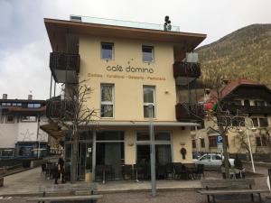 un edificio con un letrero que lee café dominó en Apartments Domino en Campo Tures