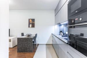 una cucina con armadi bianchi e un forno a piano cottura nero di Modern Comfort Apartment Gdansk Oldtown a Danzica