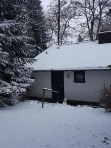 a snow covered house with a snow covered roof at Ferienhaus Ammermann in Lissendorf