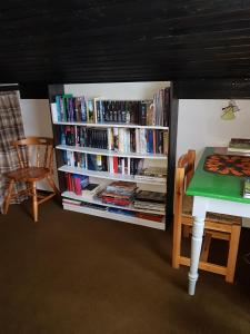 a book shelf filled with books next to a table at Ferienhaus Ammermann in Lissendorf