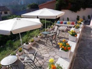un patio con tavoli, sedie e ombrellone di Maritimo Apartments a Kotor (Cattaro)