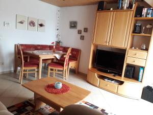 ein Wohnzimmer mit einem Tisch und einem Esszimmer in der Unterkunft Ferienwohnung Kleine in Norddeich