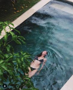 a woman is swimming in a swimming pool at Locomotive Hotel and Spa by EPS in Nusa Lembongan