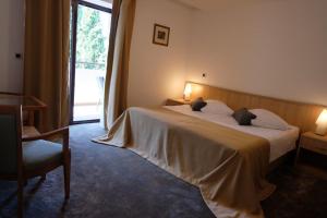 a hotel room with a large bed and a window at Hotel Flores in Poreč