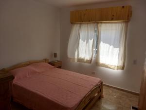 ラス・トニナスにあるMajomi Las Toninasのベッドと2つの窓がある寝室