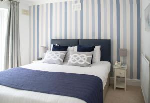 a bedroom with a bed with blue and white stripes at Berry Head Hotel in Brixham
