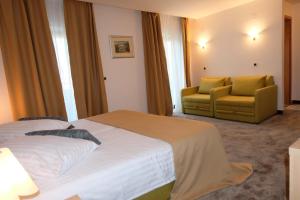 a hotel room with a bed and two chairs at Hotel Flores in Poreč