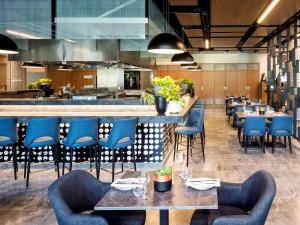 a man in a blue shirt is working in a restaurant at Novotel Brisbane South Bank in Brisbane