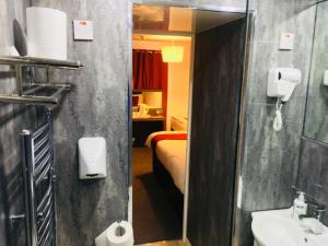 a bathroom with a sink and a bed in a room at Hotel Express Newcastle Gateshead in Newcastle upon Tyne