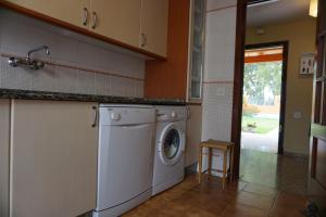 a kitchen with a washing machine and a stool at Villa Valdelagrana fantástica para familias in Cádiz