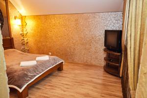 a bedroom with a bed and a flat screen tv at Инь-Янь in Vinnytsya