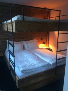 two bunk beds with white blankets and pillows at Le Bijou in Zermatt