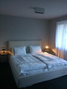 a bedroom with a large bed with white sheets and a window at Le Bijou in Zermatt