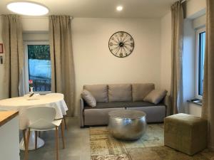 a living room with a couch and a clock on the wall at Vila Burbonka in Nova Gorica