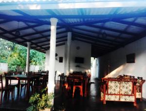comedor con techo azul, mesas y sillas en Yapagama Village, en Dambulla