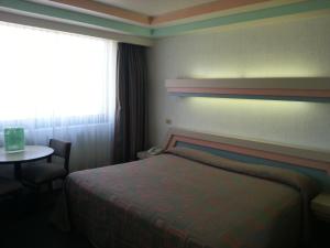 A bed or beds in a room at Hotel Puebla