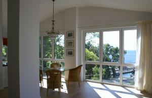 a dining room with a table and a large window at Bel Etage in der Villa Amelie am M in Sassnitz