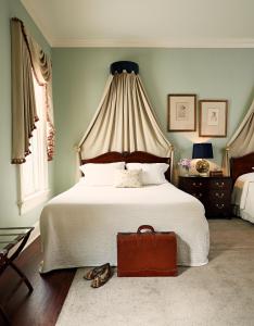 1 dormitorio con 1 cama grande y 1 maleta marrón en John Rutledge House Inn, en Charleston