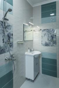 biała łazienka z umywalką i prysznicem w obiekcie Emmar Zlatograd w mieście Złatograd