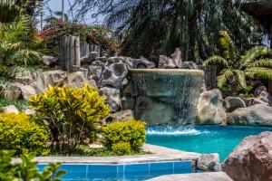a waterfall in a swimming pool with a fountain at Monteverde Boutique Hotel in Pacasmayo