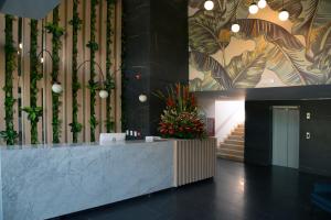 a lobby with a reception desk with plants on the wall at Hotel Plaza del Lili in Cali