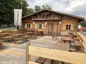 a wooden building with wooden tables and benches at Oktoberfest Wiesn Camp Lodge in Munich