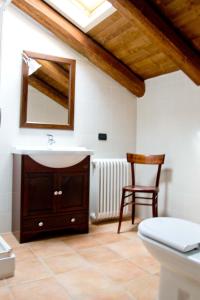 a bathroom with a sink and a mirror and a chair at Agriturismo Monbertola in Govone