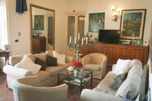 a living room with couches and chairs and a tv at Antica Dimora Caruso in Catania