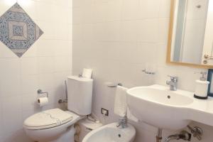 a white bathroom with a toilet and a sink at Antica Dimora Caruso in Catania +30 photos