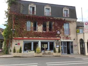 a building covered in ivy on the side of a street at The Originals City, Hôtel Le Cheval Rouge, Tours Ouest (Inter-Hotel) in Villandry