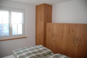 ein Schlafzimmer mit einem Bett, einem Schrank und einem Fenster in der Unterkunft Chalet Foresta in Bettmeralp