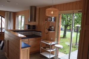 a kitchen with wood paneling and a island with a counter at Les Chènevottes au Hameau 1936 in Cherveux