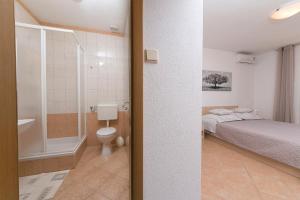 a bedroom with a bed and a bathroom with a toilet at Seaview Center House Brela in Brela