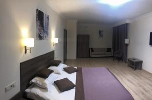 a room with a bed, a chair, and a lamp at Non-stop hotel in Boryspil