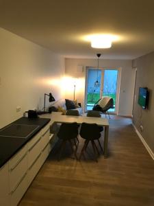 eine Küche und ein Wohnzimmer mit einem Tisch und Stühlen in der Unterkunft Luxus Apartment Lake&City in Friedrichshafen
