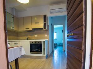 een keuken met witte kasten en een houten vloer bij Casa Nella in Urbino